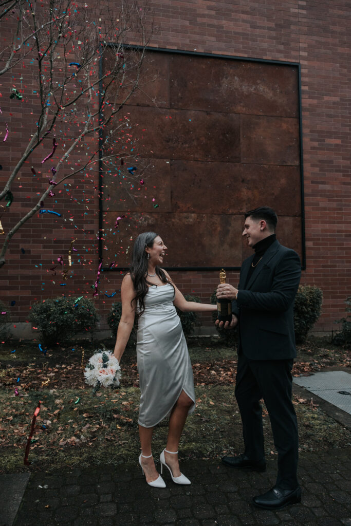 Couple celebrating outdoors with colorful confetti falling around them, showcasing fun and modern wedding send-off ideas.